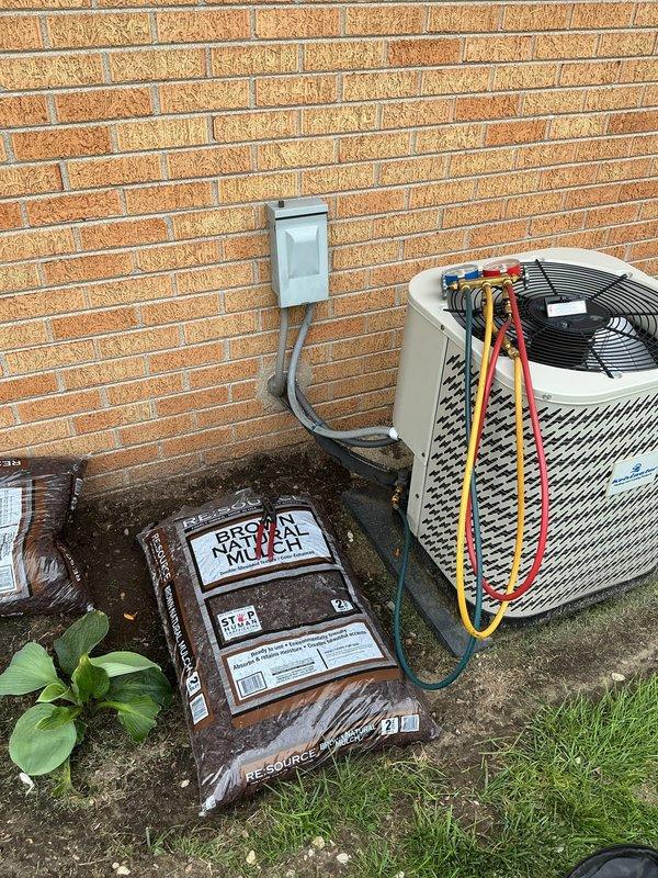 Responded to no cooling call on 19-year-old residential air conditioning system. Customer reported unit stopped cooling the previous night and was unfamiliar with equipment details after recently moving into the property. Accessed outdoor condensing unit located against exterior brick wall and furnace in garage via customer-provided entry.

Upon arrival, performed visual inspection of outdoor unit revealing aged cylindrical condenser with significant wear on concrete pad and surrounding area. Connected manifold gauges using service ports with refrigerant lines to assess system pressures and diagnose cooling failure. Evaluated electrical disconnect, condensing unit components, and refrigerant circuit for potential failures common in systems approaching two decades of service life.

Given the advanced age of the equipment at 19 years—well beyond typical 10-15 year expected lifespan—discussed findings with customer regarding system condition and repair versus replacement considerations. D