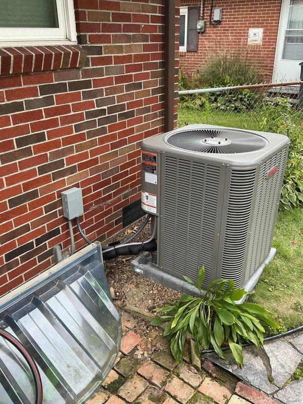 Completed installation of a new 3-ton air conditioning system with matching evaporator coil in residential utility space. Installed Size C evaporator coil measuring 21" width x 24.5" height x 21.25" depth, connected with refrigerant line set under 30 feet to new outdoor condensing unit positioned on concrete pad against brick exterior wall. Recovered and reused existing dual capacitor from previous system, integrated all electrical connections including disconnect box, and verified proper refrigerant charge and system operation upon startup.