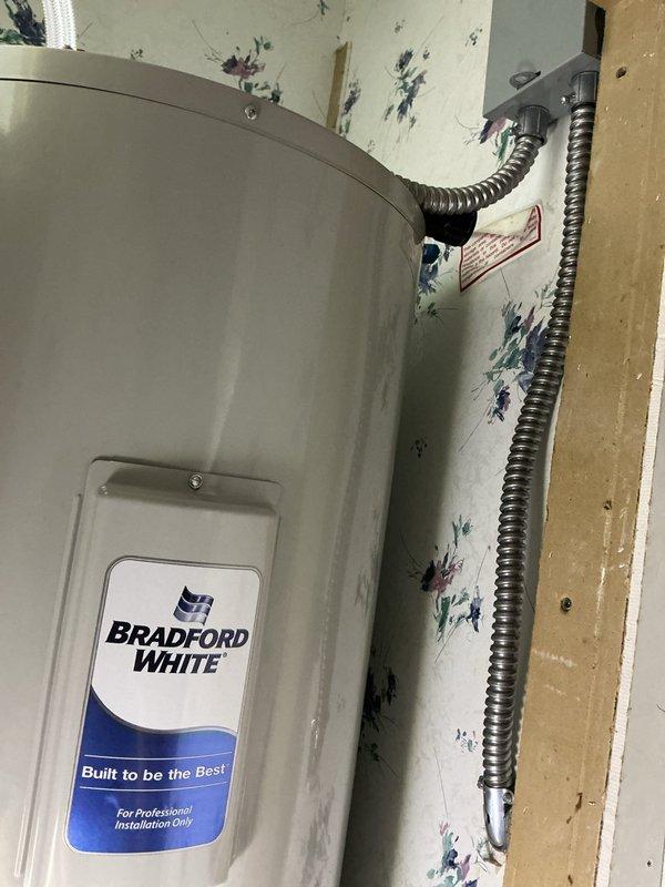 Provided estimate for conversion of existing gas-fired Bradford White water heater to new 40-gallon electric unit, including assessment of electrical supply requirements and necessary modifications to accommodate electric heating elements. Evaluated existing plumbing connections, shut-off valves, and supply lines in confined utility space for compatibility with proposed electric water heater installation and identified additional plumbing services needed to complete the conversion.