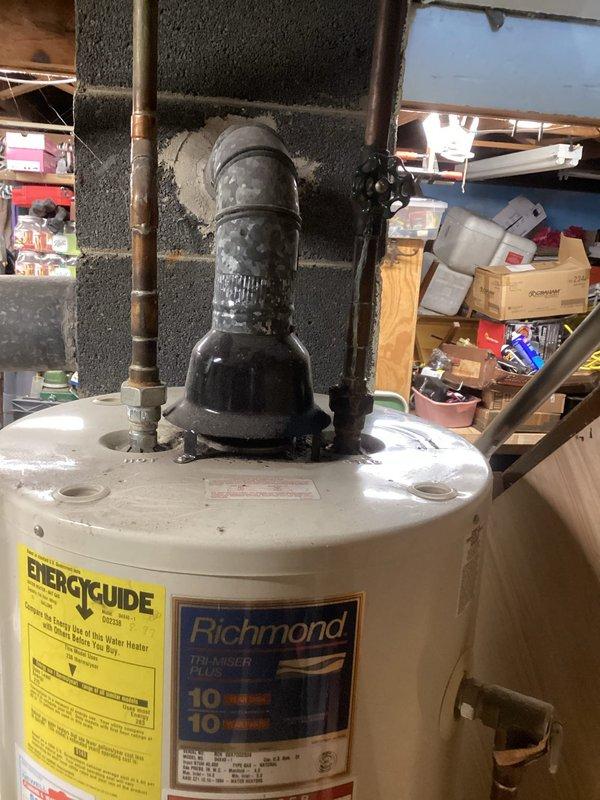 Completed comprehensive assessment of existing HVAC system and water heating equipment for replacement estimate. Evaluated Richmond brand water heater showing signs of aging infrastructure, including deteriorated black pipe assemblies and worn plumbing connections. Documented current equipment specifications, plumbing configurations with copper pipe installations, valve conditions, and mechanical room layout in basement utility area. Photographed existing installations to provide detailed visual reference for proposed furnace and water heater replacement project, capturing connection points, clearance requirements, and spatial considerations for new equipment installation.