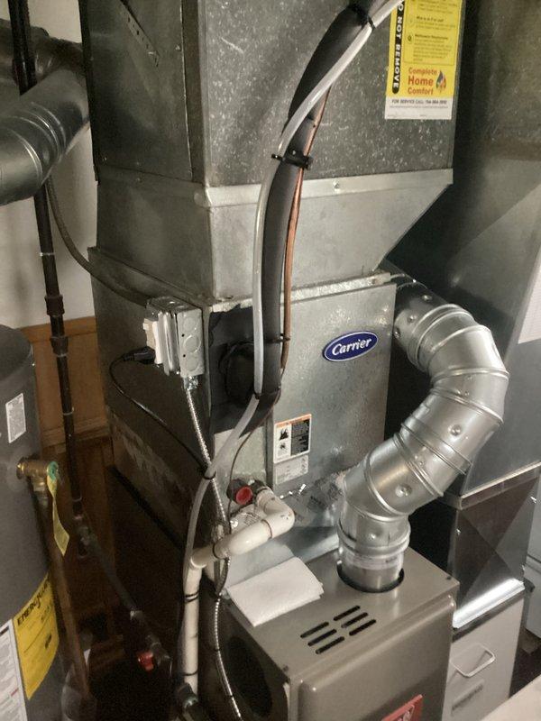 Conducted comprehensive assessment of existing residential HVAC system for complete air conditioning replacement. Evaluated current Carrier furnace installation, associated ductwork configuration, and overall system infrastructure in basement utility area. Documented existing equipment conditions including metallic ductwork routing, refrigerant line placement, and furnace unit specifications. Photographed current system layout showing rigid and flexible duct connections, copper tubing runs, and integration with existing water heater placement. Provided detailed replacement estimate for new air conditioning equipment compatible with current furnace and ductwork configuration.