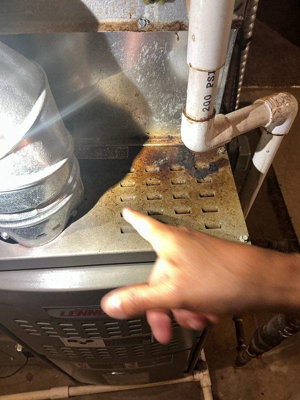 Completed preventative maintenance tune-up on 4-year-old Lennox HVAC system. Inspection revealed significant rust and corrosion on heat exchanger access panel and surrounding metal components, with rust staining present on nearby PVC condensate drain lines. All system components were inspected, filters checked, and unit confirmed operational despite visible surface corrosion in mechanical room environment.