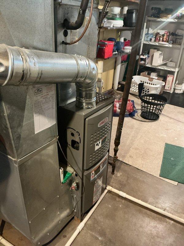 Completed preventative maintenance tune-up on 4-year-old Lennox HVAC system. Inspection revealed significant rust and corrosion on heat exchanger access panel and surrounding metal components, with rust staining present on nearby PVC condensate drain lines. All system components were inspected, filters checked, and unit confirmed operational despite visible surface corrosion in mechanical room environment.