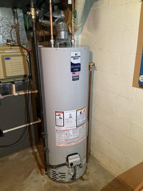 Replaced existing 40-gallon residential water heater with new Bradford White unit in basement utility room. Removed old water heater and installed new tank, connecting copper supply and discharge lines to existing plumbing infrastructure. Verified proper level installation and ensured all connections were secure. Unit installed adjacent to existing HVAC system with appropriate clearances maintained for safety and code compliance.