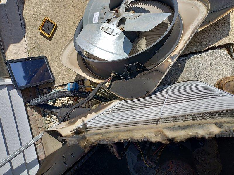 Responded to no cooling call on 20-year-old air conditioning system. Upon arrival, customer reported hearing a loud bang followed by visible sparks and fire at the outdoor condenser unit. Inspection revealed severe fire damage to the condenser unit with extensive deterioration of the coil assembly, heavy debris accumulation, and compromised electrical components. Due to the age of the equipment and catastrophic failure, recommended complete system replacement. Unit tagged out of service for safety.