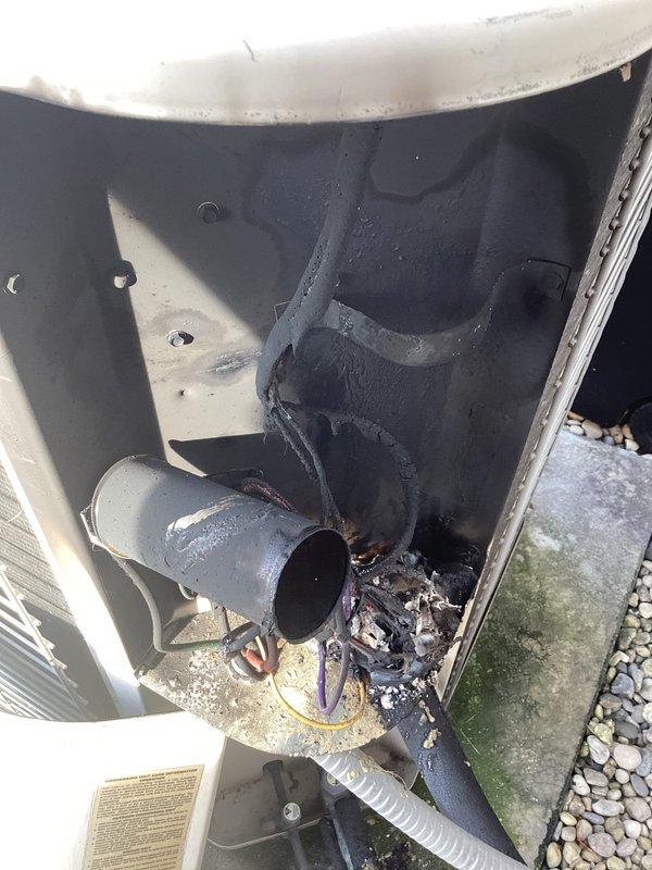 Conducted comprehensive assessment of existing HVAC system for replacement estimate. Outdoor air conditioning condenser unit evaluated and photographed, showing age-related wear on beige/tan cylindrical unit with horizontal fin configuration. Interior inspection revealed significant thermal damage to blower assembly, including visible charring, melted components, and deterioration around motor housing with damaged electrical wiring. Provided estimate for complete air conditioning replacement and potential furnace replacement based on observed equipment failure and safety concerns.