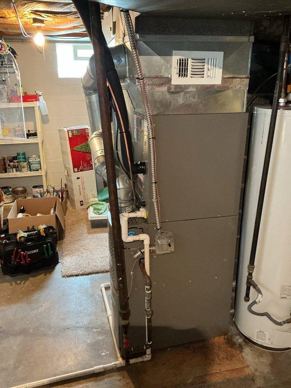 Completed full air conditioning system replacement in residential basement mechanical room. Installed 2.5-ton outdoor condensing unit with SEER2 14.3 rating on new ground pad, utilizing R454B refrigerant with 208V single-phase electrical configuration. Mounted uncased A-coil cabinet with upflow orientation to existing furnace system, featuring 3/8" liquid line and 3/4" suction line connections. Ran 15-foot copper lineset with 8-foot insulation whip between indoor and outdoor units. Installed 30/60 amp electrical disconnect for proper circuit protection per MCA 16.6 and MOP 25 specifications. Mounted programmable digital thermostat on interior wall for system control. Verified all refrigerant connections, tested system operation, and confirmed proper airflow through coil assembly. System commissioned and operational with 28,600 BTU cooling capacity at single-stage operation.