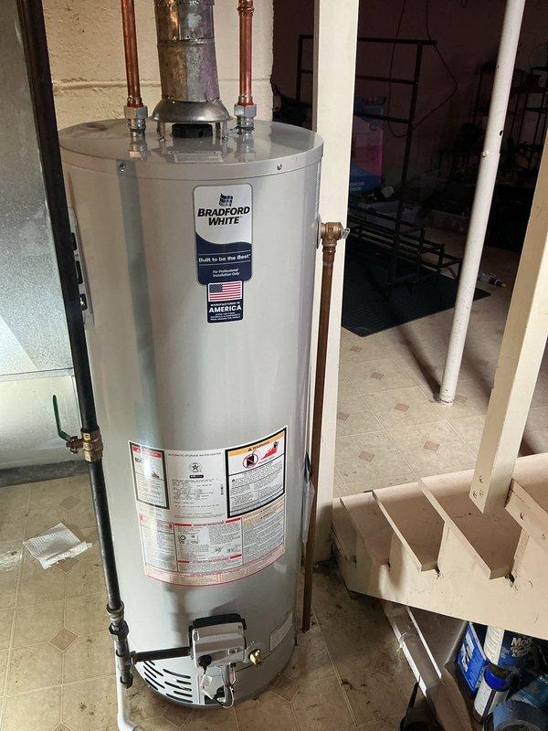 Replaced existing water heater with a new Bradford White 40-gallon atmospheric vent natural gas unit in the utility room. Installed unit includes Defender Safety System with Advanced ScreenLok Technology flame arrestor, Vitraglas tank lining with Microban antimicrobial protection, Bradford White ICON System intelligent gas control, and Hydrojet Total Performance System for sediment reduction. Connected copper supply lines with brass fittings to top-mounted inlet and outlet ports. Installed draft hood vent connector for proper atmospheric venting to building exterior. Positioned unit on white plastic overflow pan on existing tile floor. Verified all gas connections, tested for leaks, and confirmed proper venting operation. Unit operational and ready for service.