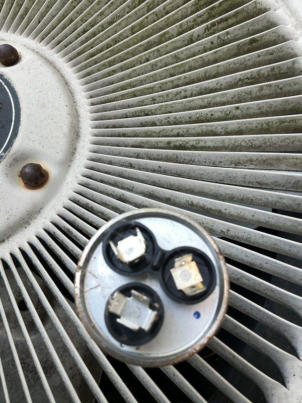 Completed comprehensive air conditioning tune-up including system diagnostics and performance verification. Tested airflow at supply register using digital multimeter, inspected and evaluated dual-run capacitor showing normal readings with terminals in good condition, and assessed outdoor condenser unit with fan grille exhibiting typical weathering and minor surface oxidation on mounting hardware.