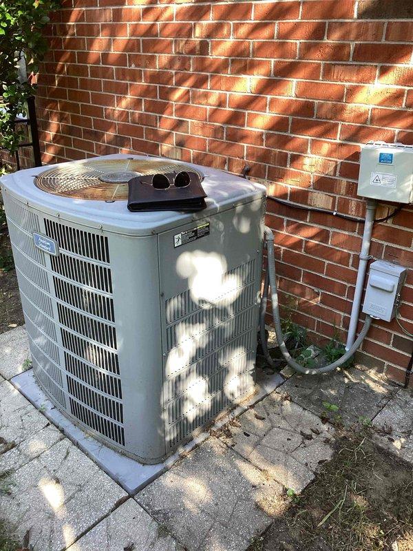 Completed comprehensive estimate for full HVAC system replacement including outdoor condenser unit and indoor furnace assembly. The existing equipment showed significant age and weathering, with the outdoor condenser unit displaying surface discoloration and dirt accumulation on its cabinet and louvers. Assessed current system configuration including electrical disconnect box, service panel connections, and metal conduit routing on exterior brick wall installation. Evaluated indoor green furnace unit with associated white PVC intake and exhaust venting system, insulated flexible ductwork, copper refrigerant line sets, and mounting hardware in basement mechanical room. Documented equipment specifications, venting configurations, and electrical service requirements. Photographed both indoor and outdoor components to provide detailed assessment for complete system replacement proposal.