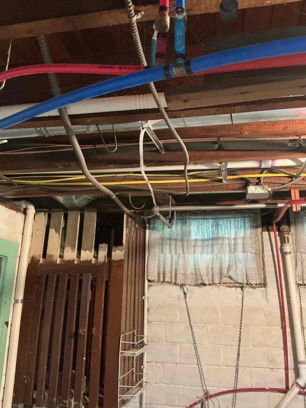 Responded to no-cooling complaint on five-year-old air conditioning system that failed to operate following recent maintenance visit approximately one week prior. Upon arrival, confirmed unit would not energize despite homeowner attempts to cycle power at furnace. Performed diagnostic evaluation of system components, inspected electrical connections, and verified thermostat communication. Documented existing installation conditions in basement mechanical area showing ductwork, support structure, and related HVAC infrastructure. System restored to normal operation and cooling function verified before departure.