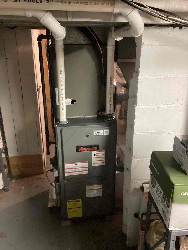 Conducted on-site evaluation for furnace replacement at residential property. Assessed existing Amana furnace installation in basement utility area, documenting current system configuration including PVC venting, copper refrigerant lines with insulation, and electrical connections. Inspected ceiling infrastructure and ductwork access points to determine compatibility requirements for new equipment installation. Photographed existing setup and provided comprehensive replacement estimate to homeowner.