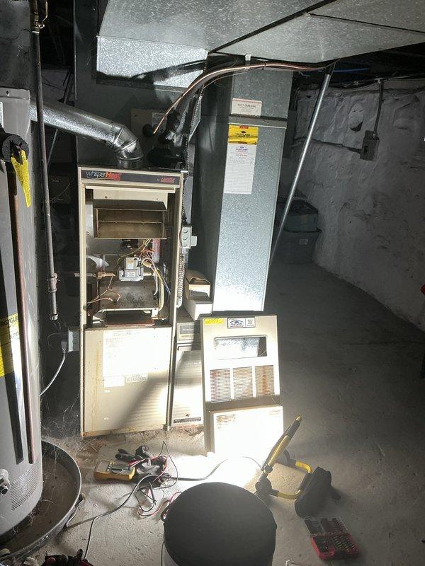 Responded to service call for 30+ year old air conditioning system experiencing intermittent operation requiring multiple power cycles before starting. Performed diagnostic inspection of HVAC system including furnace with electronic air cleaner and humidifier unit installed in 2013. Documented equipment condition with photos showing significant rust staining and deterioration on interior cabinet surfaces, indicating moisture exposure and age-related wear. Quoted maintenance service to address operational issues with cooling system and non-functioning humidifier component.