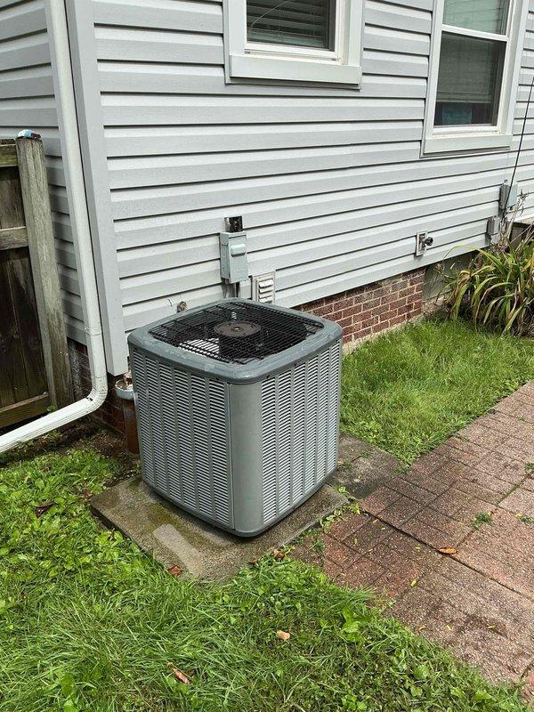 # HVAC Service Completed

Responded to service call for outdoor air conditioning unit displaying error code. Upon arrival, inspected 15-year-old residential AC system located on concrete pad in backyard area. Unit is a gray/silver condensing unit with vertical slats and black protective fan grille on top.

Performed comprehensive diagnostic evaluation of the system. Checked electrical connections at outdoor disconnect box mounted on house exterior. Inspected refrigerant lines, electrical conduit runs, and all external components for visible damage or wear. Verified proper unit positioning and clearances around equipment.

Assessed condenser coil condition through protective grille and examined fan motor operation. Tested system startup sequence and monitored for abnormal sounds or vibrations. Cleared error code and verified system returned to normal operating parameters. Unit cycling properly with no further fault codes detected.

Confirmed adequate airflow through condenser coils and 