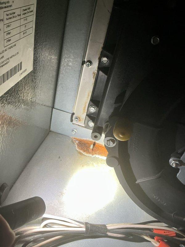 Performed comprehensive tune-up on 26-year-old air conditioning system. Inspection revealed significant corrosion on interior mounting bracket assembly and heavy accumulation of dirt and debris on evaporator coil fins, particularly in lower sections. Documented equipment condition including deteriorated components and contaminated heat exchanger surfaces for maintenance records.