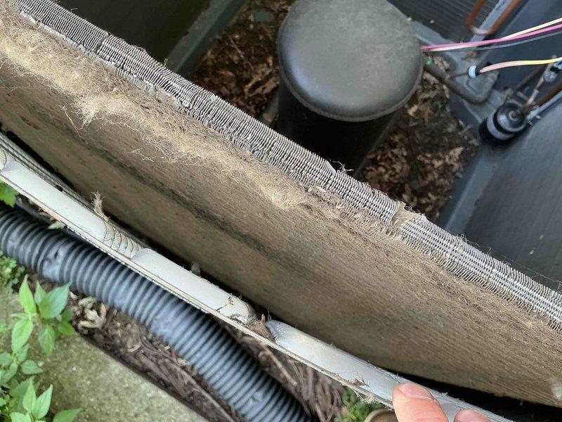 # HVAC Service Completed

Responded to no cooling complaint on residential air conditioning system. Upon arrival, performed visual inspection of outdoor condensing unit and associated components. 

Found evaporator coil heavily contaminated with dirt, dust, and debris accumulation, significantly restricting airflow through aluminum fins. The excessive buildup was preventing proper heat transfer and causing system performance degradation. Documented condition with photographs showing extent of contamination on coil fins and surrounding components.

Inspected electrical connections, refrigerant lines, and condensate drainage system. Verified unit positioning on concrete pad and checked conduit routing from electrical meter to condensing unit. All electrical connections and line sets appeared secure with proper insulation intact.

Cleaned evaporator coil thoroughly to restore airflow and heat transfer efficiency. Removed accumulated debris from fins and surrounding areas. Verified condens