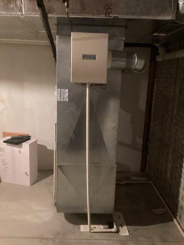 Completed comprehensive HVAC system evaluation for full equipment replacement, assessing both the outdoor condensing unit located on exterior wooden deck platform and the indoor air handling unit positioned in basement mechanical room. Documented existing system configuration including electrical conduit routing, ductwork connections, and current equipment placement to provide accurate replacement specifications and installation requirements.