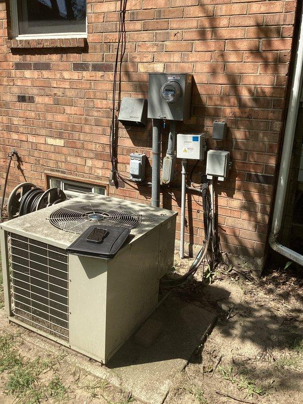 Completed comprehensive estimate for full HVAC system replacement at residential property. Evaluated existing outdoor condensing unit positioned against brick exterior wall near electrical meter and assessed indoor Conquest 80 furnace with connected air handler in basement utility area. Documented current system configuration including electrical disconnects, conduit runs, PVC venting, and ductwork connections to provide accurate replacement specifications and equipment sizing recommendations.