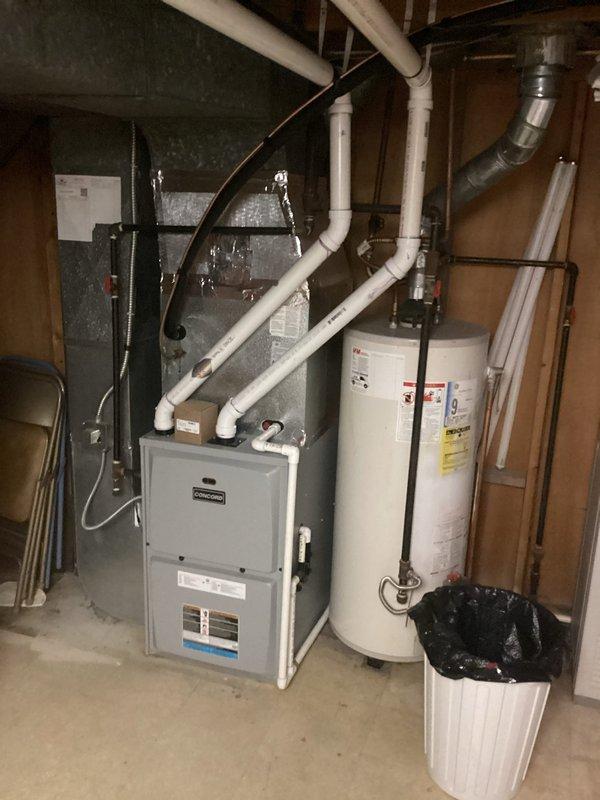 Completed comprehensive evaluation of existing HVAC system in basement utility area for air conditioning replacement estimate. Inspected current furnace unit with associated ductwork configuration, including gray flexible ductwork connections and white PVC condensate drainage system. Assessed existing infrastructure including metal supply ducts, return air pathways, and electrical conduit routing to determine compatibility with new AC installation. Documented equipment layout, clearance requirements, and existing piping arrangements to provide accurate replacement specifications for new air conditioning system that will integrate with current heating equipment.
