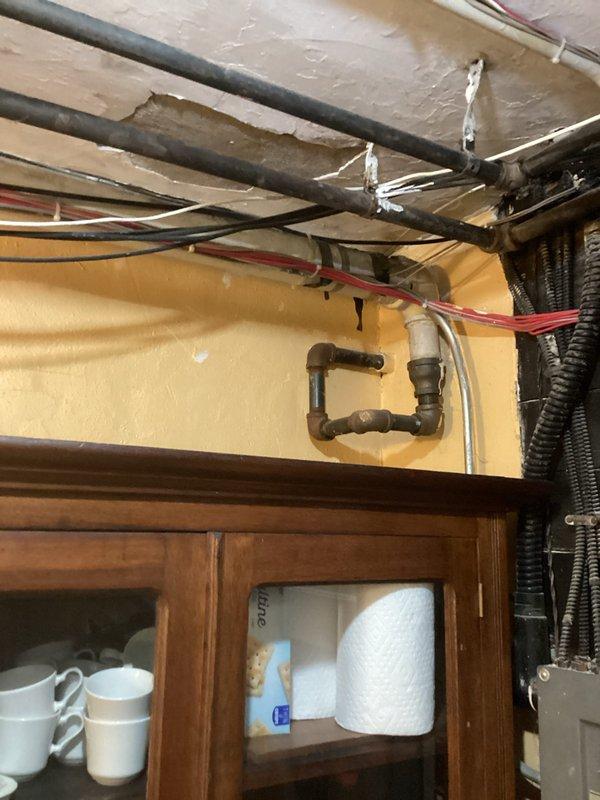 Provided estimate for installation of gas line to supply decorative fireplace. Assessed existing gas infrastructure in basement/crawlspace area beneath kitchen cabinetry and determined routing path to reach fireplace location in main living area. Proposed gas line installation would require running black iron pipe from existing gas supply through floor joists to terminate at fireplace with appropriate shutoff valve and connection for gas log set.