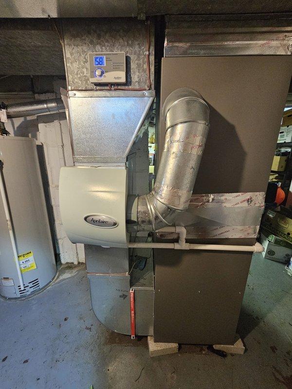 Installed a 96% efficiency upflow furnace rated at 90,000 BTU in basement location. Replaced approximately 20 feet of 2-inch PVC venting system with proper pitch and termination. Installed metal spacer to ensure proper clearances and code compliance. Connected 120-volt condensate pump to handle moisture removal from high-efficiency system. Replaced damaged supply register in existing ductwork to restore proper airflow. Mounted and programmed Honeywell digital thermostat for system control. Integrated Aprilaire humidifier with new furnace installation. Verified all electrical connections, gas line integrity, and proper combustion air supply. Tested system operation through complete heating cycle, confirmed proper ignition sequence, and validated safety controls. All work performed to manufacturer specifications and local building codes.