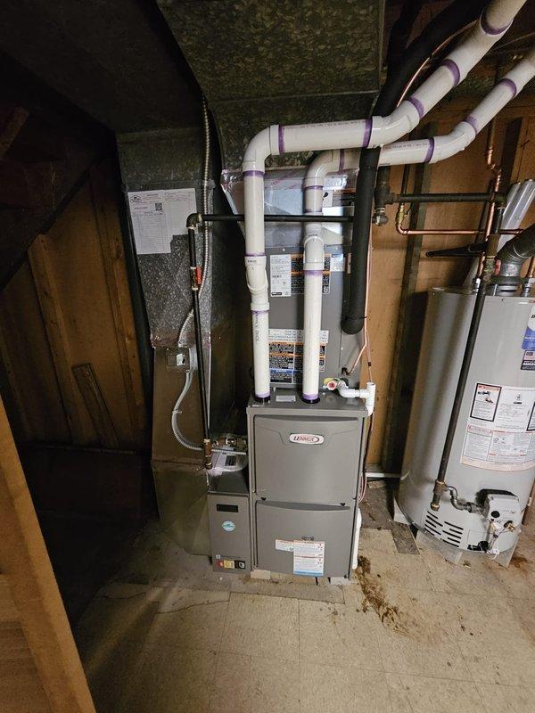 Completed full HVAC system installation in basement utility room including Lennox 96% efficiency 70,000 BTU upflow furnace with cased evaporator coil and 5" metal filter rack. Installed single-stage condenser unit with new 3/4" x 25' lineset, concrete equipment pad, electrical disconnect, and whip connection. Set WiFi-enabled thermostat for remote system control and installed new 40-gallon water heater with copper supply connections. All equipment properly mounted, leveled, and secured per manufacturer specifications with PVC venting routed along ceiling joists.