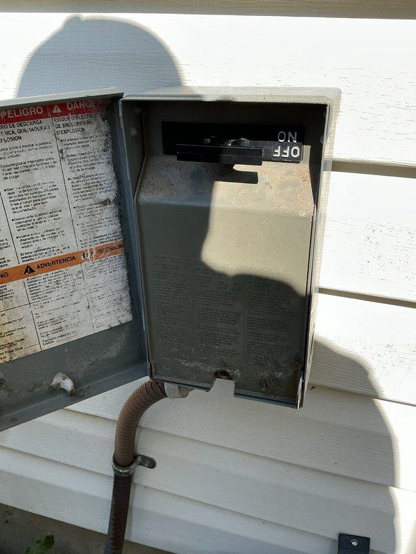# HVAC Service Report - No Cooling Issue

Responded to service call for 10-year-old air conditioning system that stopped operating immediately following routine annual maintenance. Upon arrival, performed diagnostic assessment of outdoor condensing unit and associated electrical components.

Investigation revealed that the external disconnect switch had been left in the OFF position following the previous maintenance visit. The disconnect box, mounted on exterior siding, showed the switch clearly positioned to OFF as visible in documentation photos. This external safety disconnect is a standard component that allows technicians to de-energize the unit during service work.

Verified that all other system components appeared intact with no visible damage to wiring, conduit, or the disconnect enclosure itself. The unit had adequate power supply to the disconnect location, and no tripped breakers were found at the main electrical panel.

Corrected the issue by returning the disconnect swit