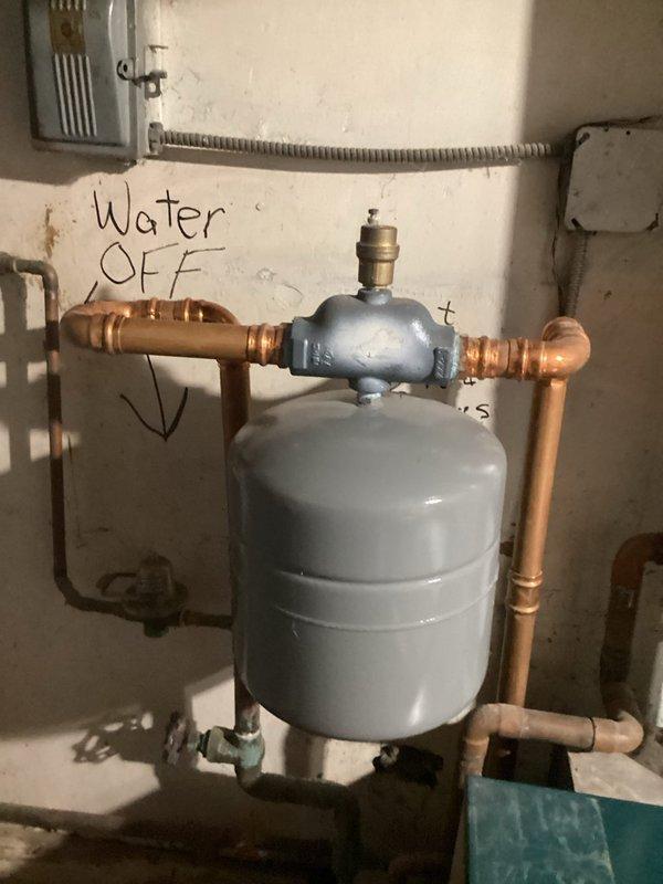 Conducted comprehensive boiler system estimate at residential property. Inspected existing heating infrastructure including expansion tank, copper piping network, isolation valves, and associated plumbing components in basement mechanical room. Documented current system condition showing aged copper pipes with significant oxidation and patina, brass fittings with visible weathering, and expansion tank configuration. Photographed plumbing layout including water shutoff valve locations, flexible conduit connections, and pipe routing throughout utility space. Assessed overall system age and wear patterns to determine replacement requirements and provide accurate estimate for new boiler installation and necessary plumbing modifications.