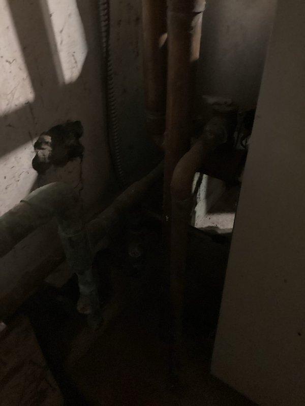 Conducted comprehensive boiler system estimate at residential property. Inspected existing heating infrastructure including expansion tank, copper piping network, isolation valves, and associated plumbing components in basement mechanical room. Documented current system condition showing aged copper pipes with significant oxidation and patina, brass fittings with visible weathering, and expansion tank configuration. Photographed plumbing layout including water shutoff valve locations, flexible conduit connections, and pipe routing throughout utility space. Assessed overall system age and wear patterns to determine replacement requirements and provide accurate estimate for new boiler installation and necessary plumbing modifications.