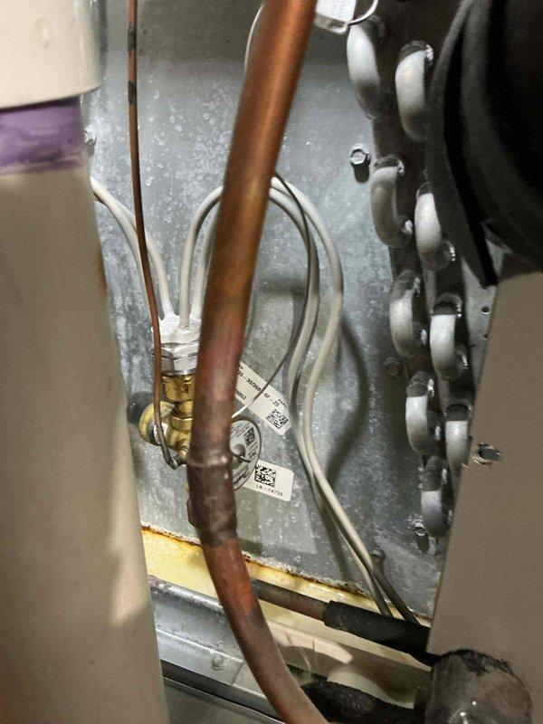 Completed comprehensive air conditioning tune-up service on residential HVAC system. Performed standard maintenance inspection of evaporator coil assembly and refrigerant line connections, verified proper operation with visible condensation indicating active cooling cycle, and documented system condition with no immediate repairs required at time of service.