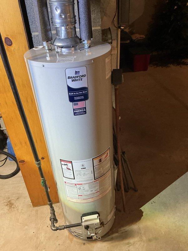 Installed a 40-gallon slim Bradford White natural gas water heater in basement utility area, replacing the existing unit. Replaced the cold water inlet shutoff valve with new components and installed fresh fittings throughout the installation per specifications, ensuring no old fittings were reused to maintain system integrity and code compliance.