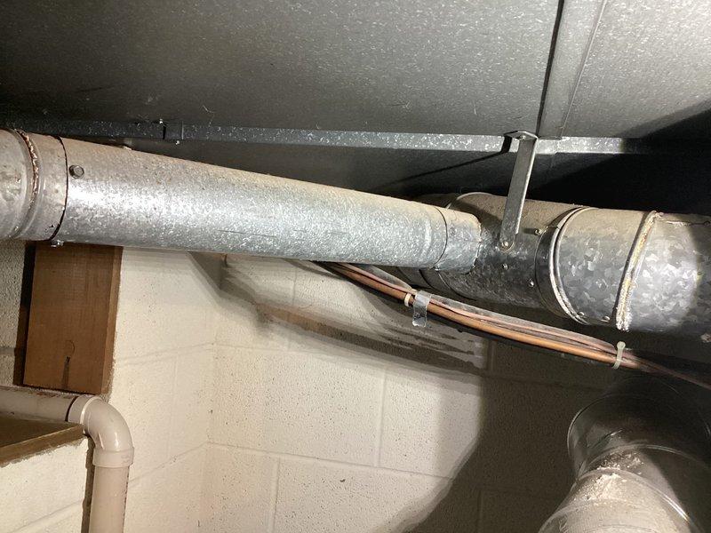Conducted comprehensive assessment of existing HVAC system and infrastructure in basement mechanical room for equipment replacement estimate. Documented current furnace installation, water heater configuration, and complete ductwork layout including aged insulated supply and return ducts with visible wear and dust accumulation. Evaluated existing system components, mounting brackets, copper piping runs, electrical conduit routing, and mechanical room accessibility for replacement equipment installation planning.