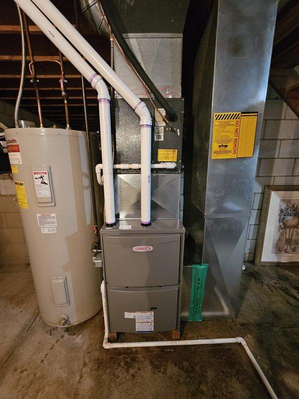 Completed installation of Lennox ML196 90,000 BTU upflow gas furnace in basement mechanical room. Removed existing furnace and replaced deteriorated return air boot assembly due to extensive rust damage. Installed new galvanized sheet metal return plenum and boot connection to ensure proper airflow and system integrity.

Ran new PVC exhaust and intake venting system in accordance with manufacturer specifications for 90%+ AFUE condensing furnace operation. Venting routed through basement ceiling joists and terminated through exterior wall. All PVC joints properly primed, glued, and secured with appropriate hangers and supports.

Installed new thermostat and completed all necessary electrical connections. Performed system startup, verified proper ignition sequence, flame characteristics, and burner operation. Confirmed adequate combustion air supply and proper condensate drainage. System tested and operating within manufacturer specifications.