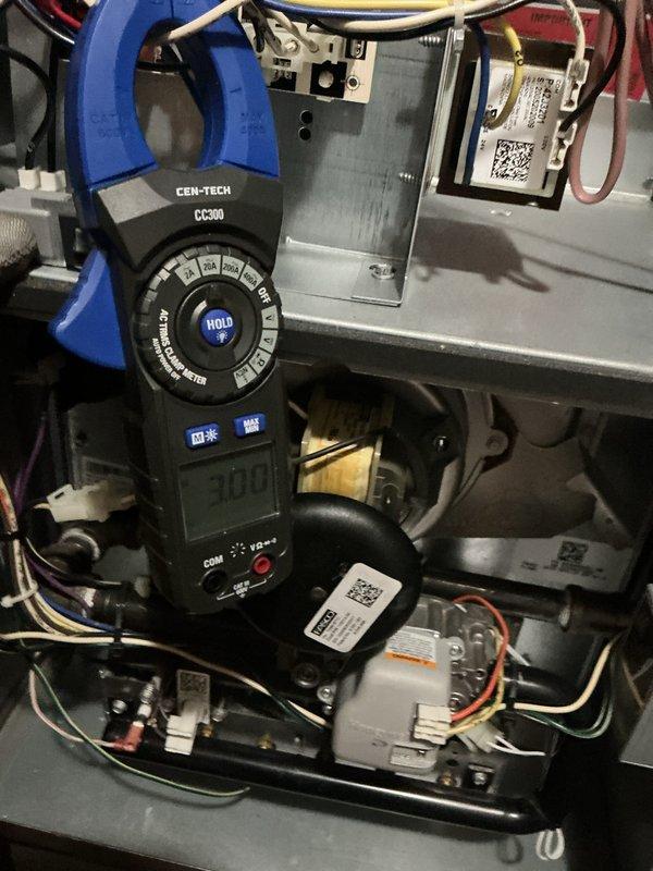 Performed comprehensive furnace maintenance on four-year-old heating system. Conducted electrical diagnostics using digital multimeter and clamp meter to verify voltage readings at 70.5V and amperage draw at 3.00A on system components. Inspected blower motor housing, air handling unit, and control board assembly. Verified all electrical connections, tested safety circuits, and confirmed proper operation of control modules. System operating within normal parameters with no issues found.