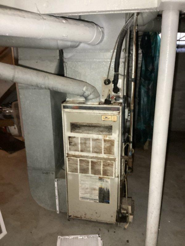 Completed furnace replacement estimate for residential basement installation. Assessed existing aging furnace unit with heavily soiled filters and evaluated current ductwork configuration, including horizontal sheet metal supply ducts and PVC venting system. Documented equipment layout, clearances, and existing infrastructure including water heater proximity and electrical connections to provide comprehensive replacement options and sizing recommendations.