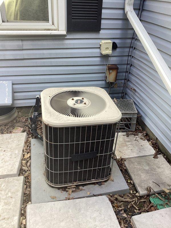 Conducted comprehensive site evaluation for complete HVAC system replacement in residential property. Assessed existing air handler unit located in attic space alongside water heater, noting current installation configuration on wooden support beams with existing electrical connections and flexible metal conduit routing. Evaluated outdoor heat pump condenser unit positioned on concrete paver pad against exterior wall with vinyl siding, including review of electrical disconnect boxes and current mounting arrangement. Documented equipment specifications, clearances, and access requirements for both indoor and outdoor components. Prepared detailed replacement estimate for new air handler and heat pump system to replace existing equipment.