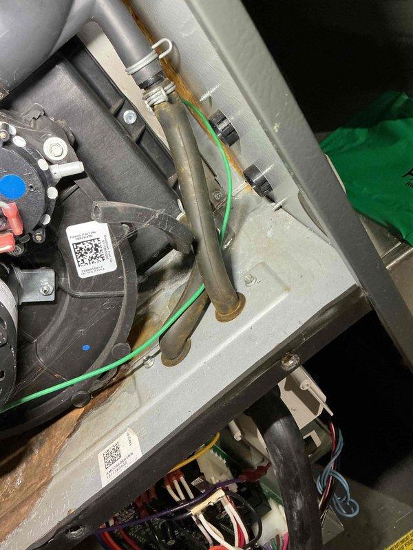 Responded to service call for water accumulation around furnace base and unusual odor reported by occupant. Performed comprehensive inspection of furnace interior components, including blower assembly, heat exchanger, condensate drainage system, and burner compartment. Examined all electrical connections, circuit boards, and wiring harnesses for signs of moisture intrusion or thermal damage. Inspected evaporator coil, condensate drain lines, and trap for blockages or leaks that could cause water pooling. Verified proper operation of inducer motor assembly and checked flue piping for condensation issues. Documented equipment condition with detailed photographs showing internal components, motor assemblies, gas valve connections, and all visible mechanical systems for service records and future reference.