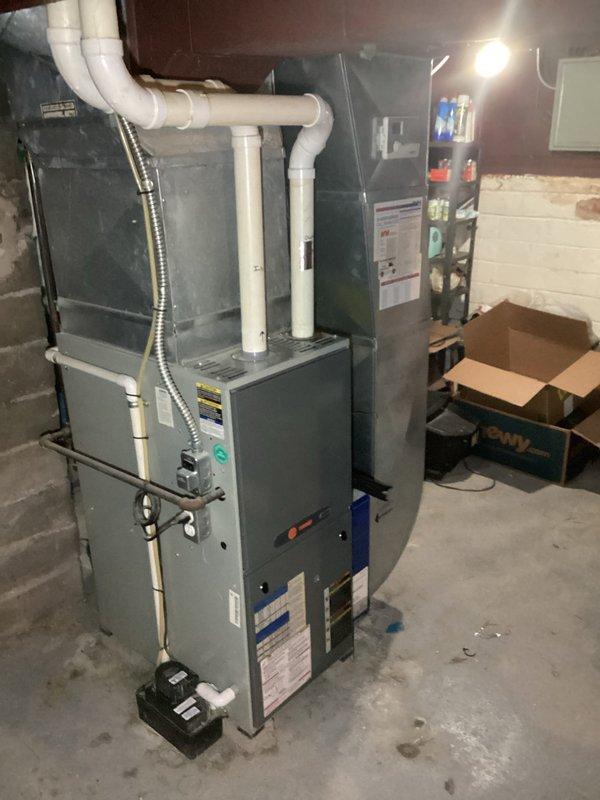 Conducted comprehensive assessment of existing HVAC system for complete replacement estimate. Evaluated current basement-installed furnace with associated PVC venting and ductwork configuration, along with exterior Trane air conditioning condenser unit. Documented equipment specifications, installation conditions, and spatial requirements for proper sizing and replacement planning. Photographed existing system layout including furnace positioning, venting arrangements, electrical connections, and outdoor condenser placement to provide accurate replacement specifications and ensure new equipment will integrate seamlessly with existing infrastructure.