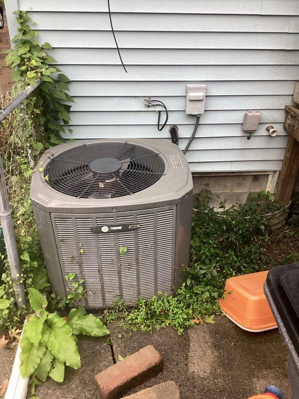 Conducted comprehensive assessment of existing HVAC system for complete replacement estimate. Evaluated current basement-installed furnace with associated PVC venting and ductwork configuration, along with exterior Trane air conditioning condenser unit. Documented equipment specifications, installation conditions, and spatial requirements for proper sizing and replacement planning. Photographed existing system layout including furnace positioning, venting arrangements, electrical connections, and outdoor condenser placement to provide accurate replacement specifications and ensure new equipment will integrate seamlessly with existing infrastructure.