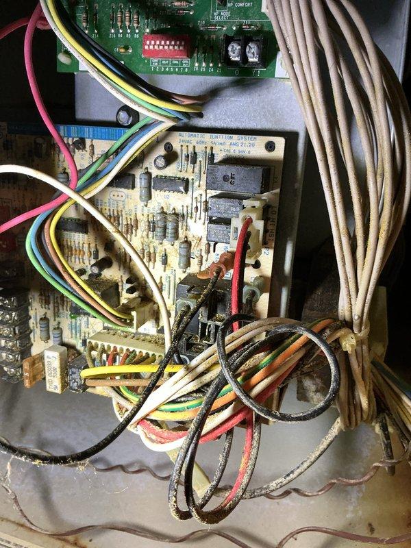 # HVAC Service Report

Responded to no heat call on 16-year-old gas furnace blowing cold air with pilot light failure. Upon inspection, found significant corrosion on control panel and circuit boards affecting ignition system operation. Control board showed visible deterioration with discolored wiring insulation and aged electrical connections throughout the unit. Multiple wire connections displayed signs of corrosion and heat damage, particularly at wire nut junctions near blower motor assembly. Documented extensive wear on both primary control board and secondary circuit boards with photographic evidence. System exhibited typical failure patterns consistent with age-related component degradation and moisture intrusion affecting electrical components. Blower motors and associated wiring showed operational stress with disorganized wire management contributing to potential failure points. Heat exchanger area and gas valve connections inspected for safety concerns related to ignition fai