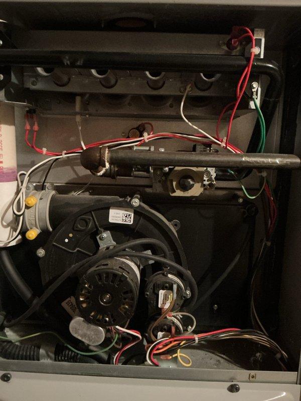 # HVAC Service Report

Responded to no heat call on 16-year-old gas furnace blowing cold air with pilot light failure. Upon inspection, found significant corrosion on control panel and circuit boards affecting ignition system operation. Control board showed visible deterioration with discolored wiring insulation and aged electrical connections throughout the unit. Multiple wire connections displayed signs of corrosion and heat damage, particularly at wire nut junctions near blower motor assembly. Documented extensive wear on both primary control board and secondary circuit boards with photographic evidence. System exhibited typical failure patterns consistent with age-related component degradation and moisture intrusion affecting electrical components. Blower motors and associated wiring showed operational stress with disorganized wire management contributing to potential failure points. Heat exchanger area and gas valve connections inspected for safety concerns related to ignition fai