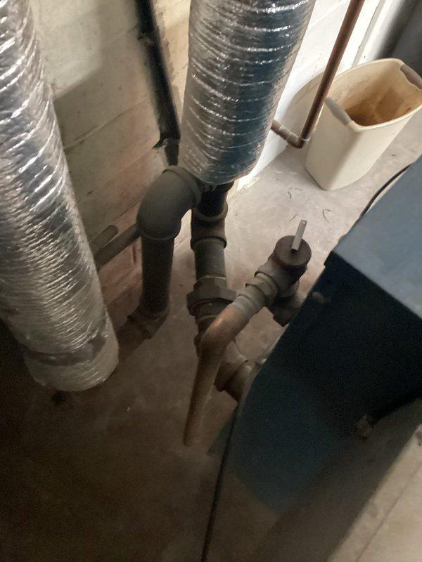 Conducted comprehensive site assessment of existing steam boiler system for replacement estimate. Inspected current mechanical room configuration including boiler unit, associated piping infrastructure, gas connections, and venting components. Evaluated spatial constraints and existing ductwork routing to determine optimal replacement equipment specifications. Documented current system layout through photographic records showing water heater, furnace unit, flexible ductwork, copper and PVC piping connections, and utility room conditions. Provided detailed replacement recommendations and specifications for new steam boiler installation.