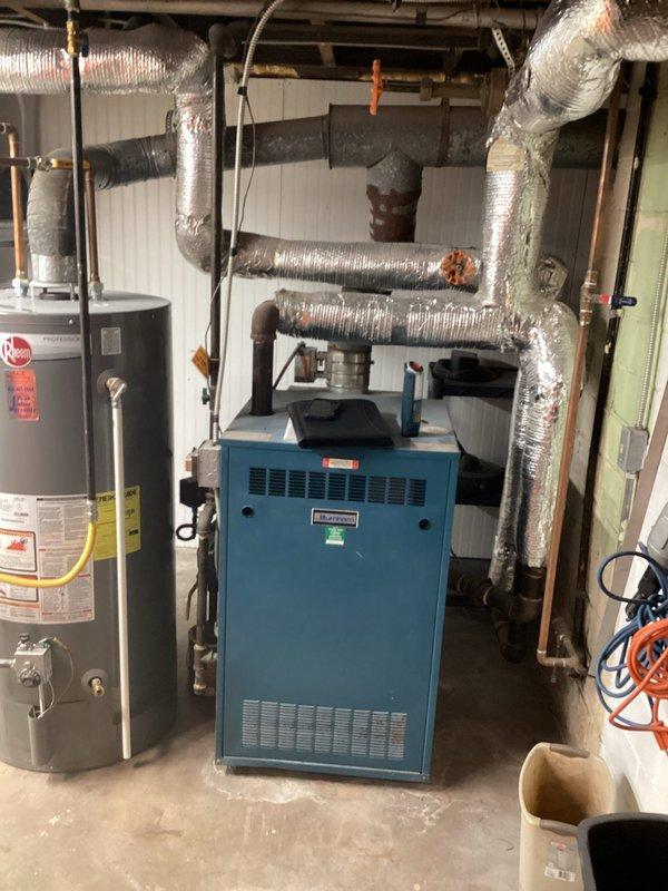 Conducted comprehensive site assessment of existing steam boiler system for replacement estimate. Inspected current mechanical room configuration including boiler unit, associated piping infrastructure, gas connections, and venting components. Evaluated spatial constraints and existing ductwork routing to determine optimal replacement equipment specifications. Documented current system layout through photographic records showing water heater, furnace unit, flexible ductwork, copper and PVC piping connections, and utility room conditions. Provided detailed replacement recommendations and specifications for new steam boiler installation.