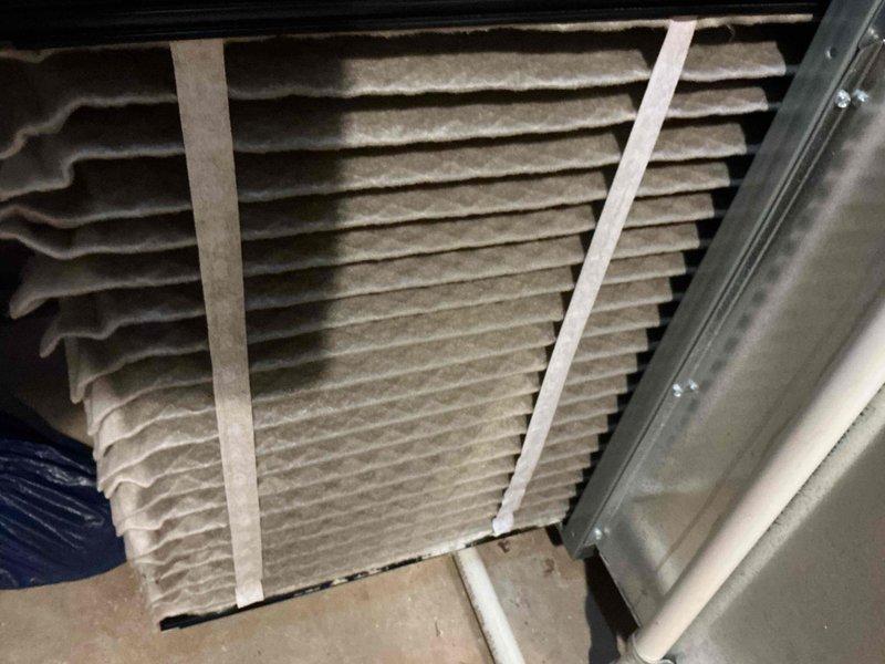 Completed comprehensive tune-up on 12-year-old residential gas furnace system. Inspected air filter showing moderate dust accumulation, verified proper installation within metal frame housing, and examined all accessible HVAC components including humidifier unit and PVC venting system. All equipment confirmed operational with no immediate service concerns identified.