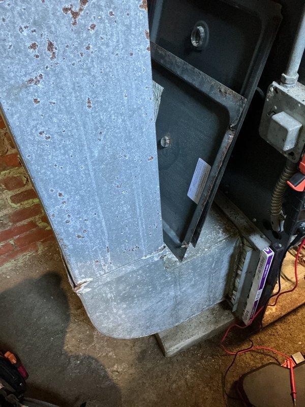 Responded to no-heat call on 20-year-old gas furnace. Upon arrival, accessed unit located in basement area. Performed diagnostic evaluation of furnace system and associated components. Inspected burner assembly, heat exchanger, blower motor, and electrical connections mounted on exterior brick wall foundation. Documented equipment condition showing significant age-related deterioration including paint oxidation, surface corrosion, and general wear on cabinet and mounting hardware. Identified failed component preventing ignition sequence. Completed necessary repairs to restore heating operation and verified proper system function before departure.