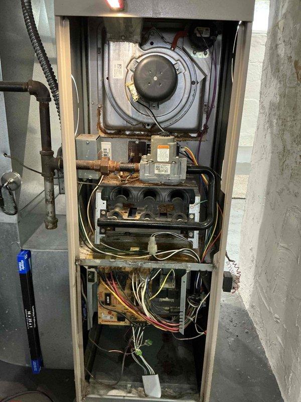 # HVAC Service Report - No Heat Call

Responded to no heat call for residential furnace that would not ignite or start. Upon inspection, found unit in operational condition with significant age-related deterioration evident throughout. Extensive rust and corrosion observed on metal components, copper piping connections, and mounting brackets indicating prolonged moisture exposure. Internal components including inducer motor assembly, gas valve, circuit boards, and blower motor showed heavy dust accumulation and discoloration consistent with extended service life.

Performed diagnostic testing and visual inspection of all major components including gas valve assembly, ignition system, inducer motor, blower assembly, and control boards. Verified proper electrical connections and wiring throughout unit. Examined condensate drainage system and associated piping. Despite customer report of non-operation, unit appeared functional during service visit, suggesting intermittent failure or issue