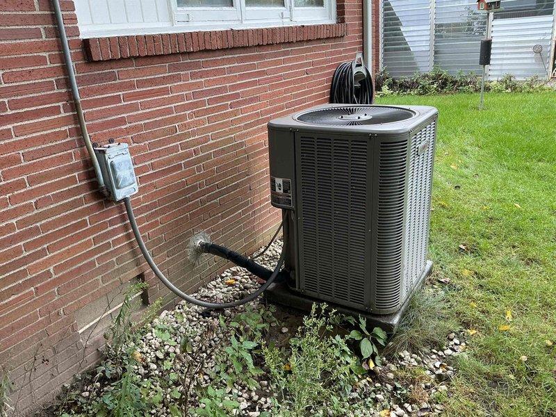 # AC Tune-Up Summary

Completed routine maintenance on a 5-year-old residential air conditioning system. Inspected outdoor condensing unit, verified electrical connections and capacitor functionality, and confirmed all components operating within normal parameters.

---

# Detailed Service Description

Performed comprehensive preventive maintenance tune-up on a residential split-system air conditioner. Upon arrival, conducted visual inspection of the outdoor condensing unit positioned on pad against brick exterior wall. Verified unit placement remained stable with adequate clearance for airflow and service access.

Removed access panel to inspect electrical compartment and internal components. Examined capacitor for signs of bulging, leakage, or deterioration—unit showed normal condition with all manufacturer labels intact and legible. Tested capacitor microfarad ratings to confirm values remained within acceptable tolerance range for proper compressor and fan motor operation.

Inspect