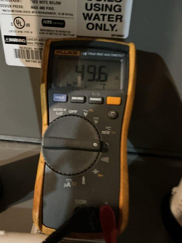 Completed furnace tune-up and system inspection. Performed diagnostic testing with multimeter, recording voltage reading of 496V at equipment. Inspected fireplace insert and protective screening as part of overall heating system evaluation.