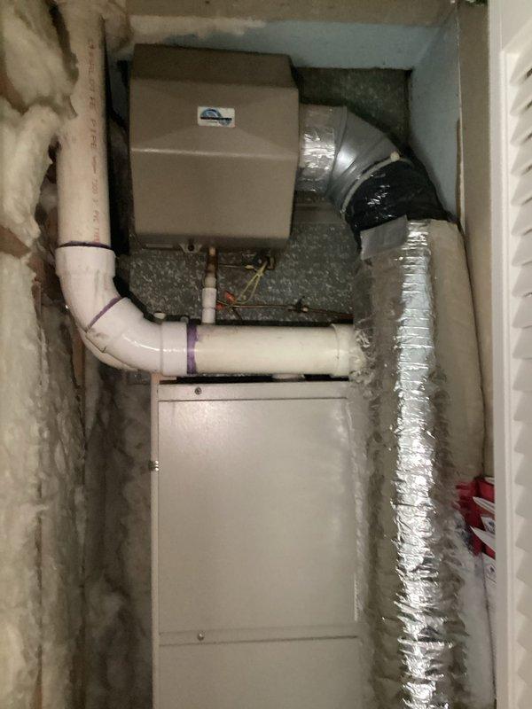 Completed furnace and HVAC system replacement estimate for residential installation located in confined utility closet space. Documented existing equipment configuration including air handler unit, humidifier, condensate drainage system with PVC piping, and flexible ductwork connections. Assessed current system layout, clearances, and accessibility for future equipment replacement considerations.
