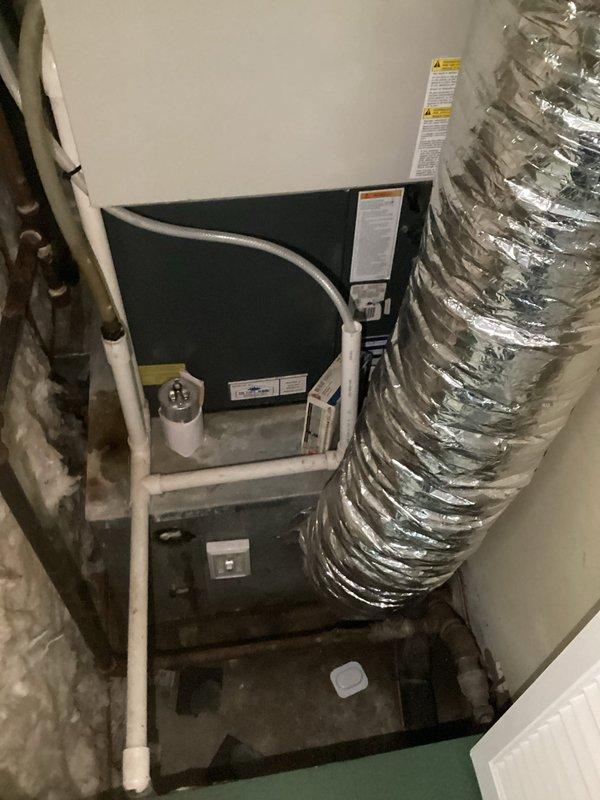Completed furnace and HVAC system replacement estimate for residential installation located in confined utility closet space. Documented existing equipment configuration including air handler unit, humidifier, condensate drainage system with PVC piping, and flexible ductwork connections. Assessed current system layout, clearances, and accessibility for future equipment replacement considerations.
